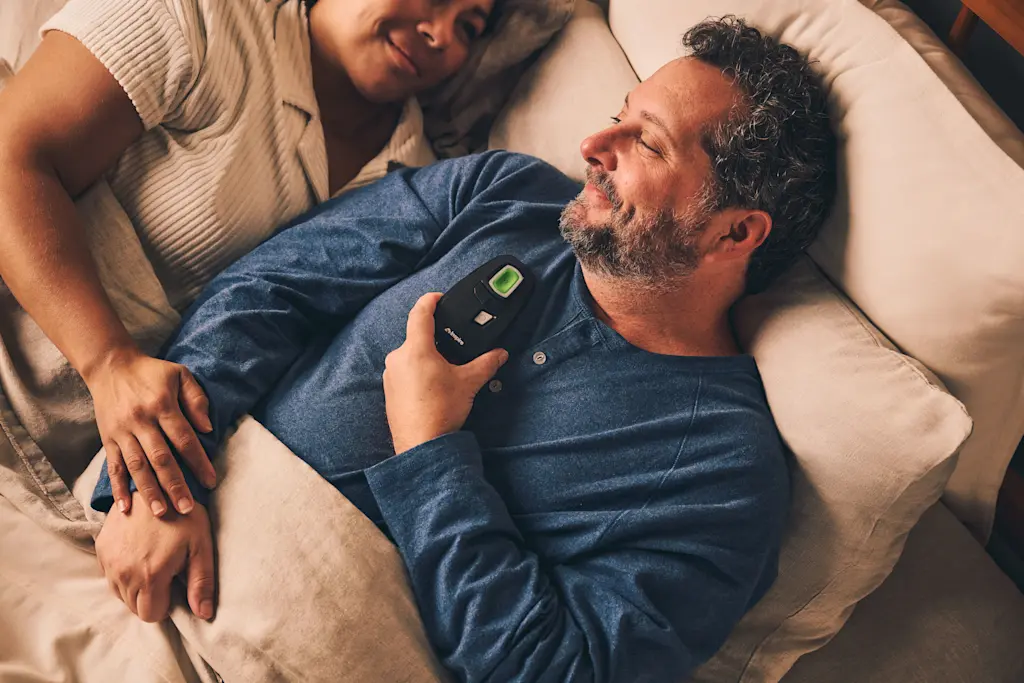 Patient using Inspire therapy remote at bedtime